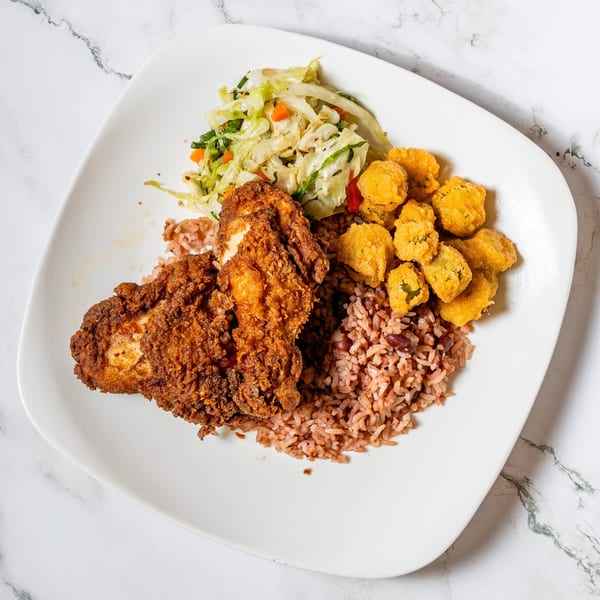 Fried chicken, rice and beans, fried okra, and coleslaw on a white plate.